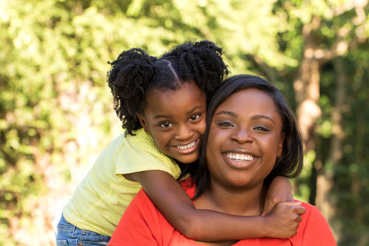 Black mother and daughter smiling