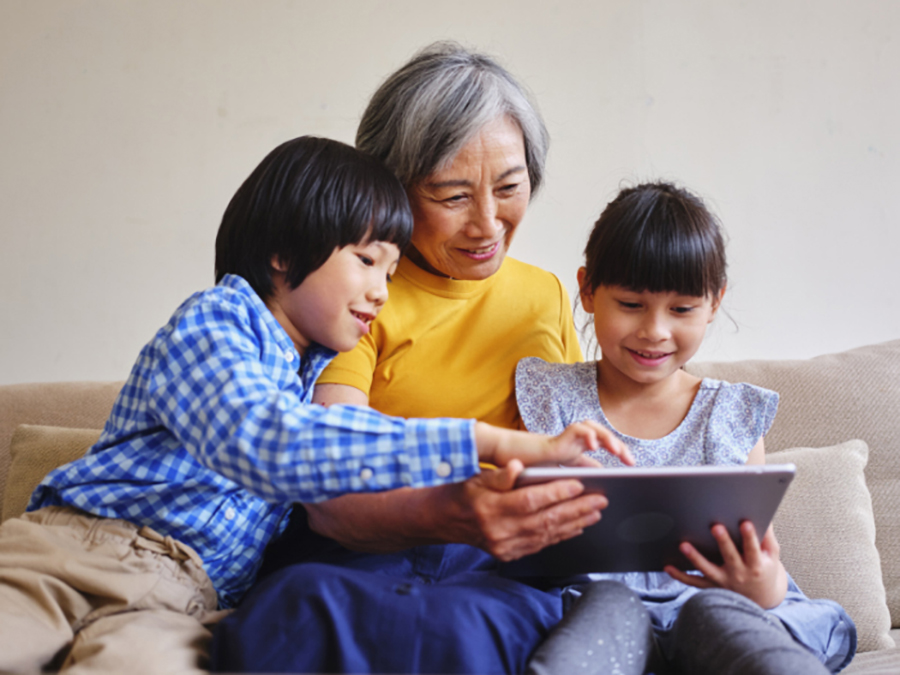 woman viewing a tablet with grand children