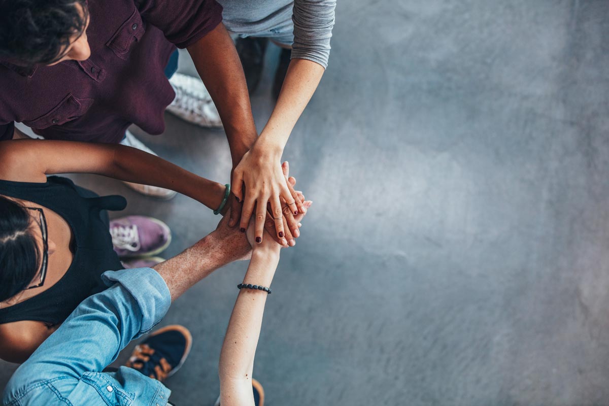 Professionals in huddle with hands together