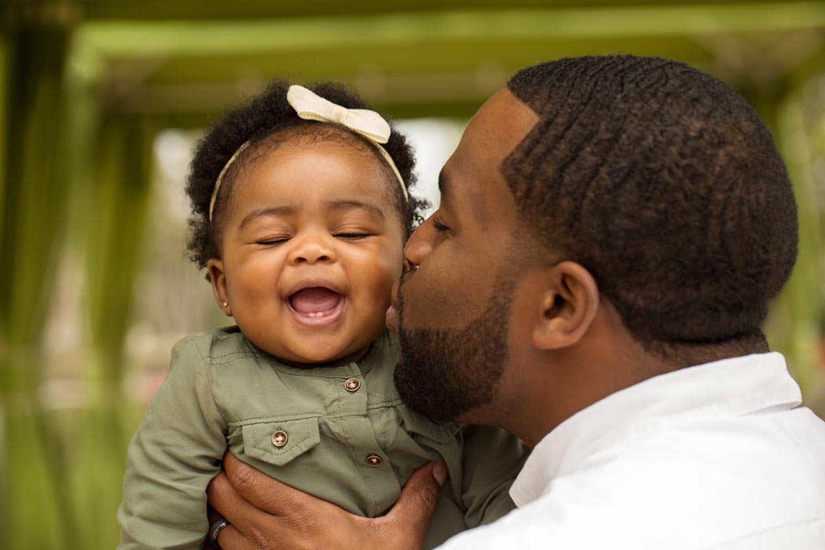 Man kissing his infant daughter on cheek Man kissing his infant daughter on cheek