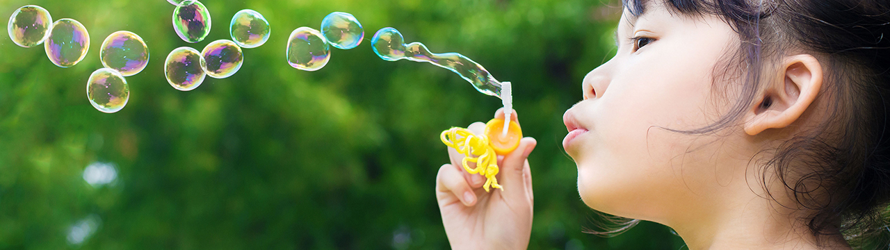 young girl blowing bubbles