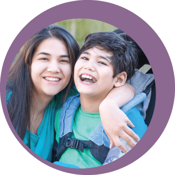 woman crouched next to boy in a wheel chair