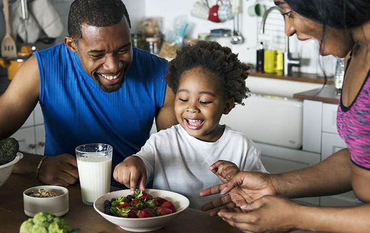 family eating fruit together at a table