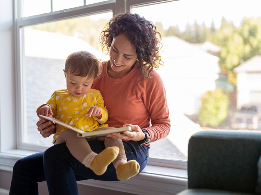 woman reading book to a small child